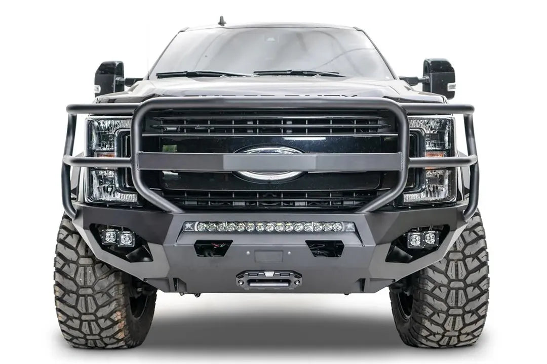 Fab Fours Matrix front bumper with full guard on a black Ford Super Duty F-250/F-350, straight-on front view, showing full grille guard hoops, the center LED light bar, cube light pods, and the integrated winch with shackle mounts