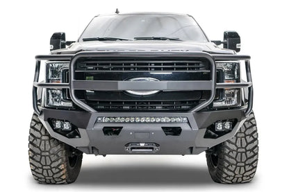 Fab Fours Matrix front bumper with full guard on a black Ford Super Duty F-250/F-350, straight-on front view, showing full grille guard hoops, the center LED light bar, cube light pods, and the integrated winch with shackle mounts