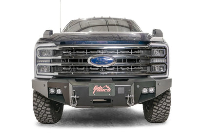 Fab Fours Premium Winch front bumper on a blue and gray two-tone Ford Super Duty F-250/F-350, straight-on front view, showing the center winch plate with fairlead, LED light pods, and D-ring shackle mounts