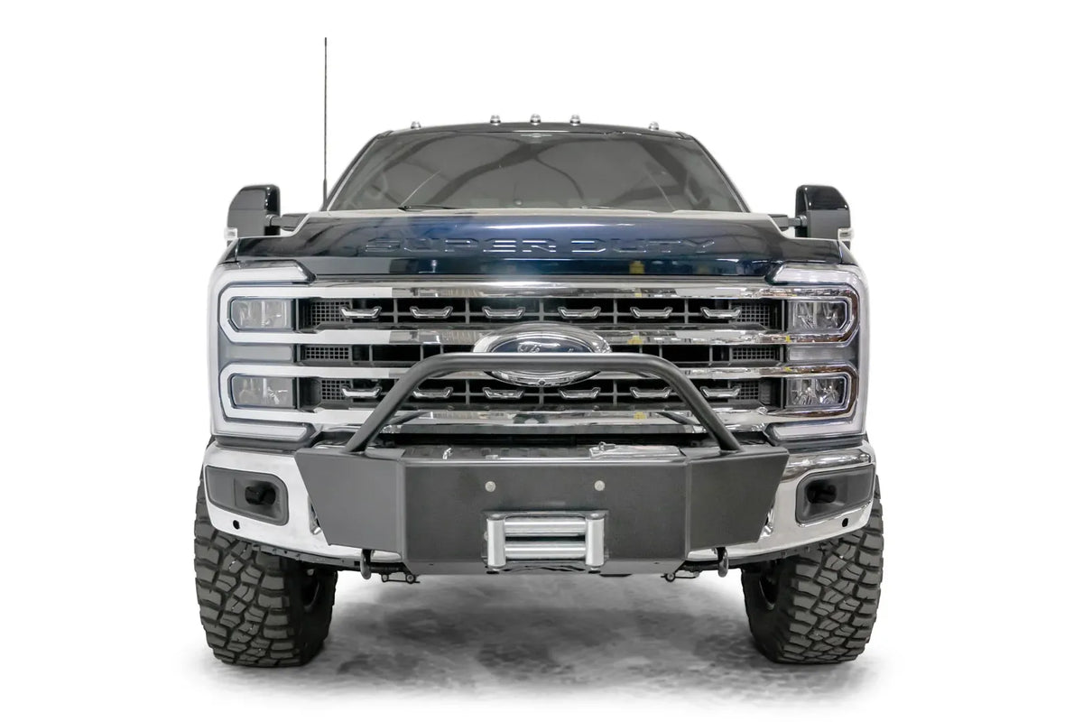 Fab Fours winch mount with pre-runner hoop on a blue and gray two-tone Ford Super Duty F-250/F-350, straight-on front view, showing the tubular pre-runner hoop, the winch mount plate with fairlead and the factory bumper integration