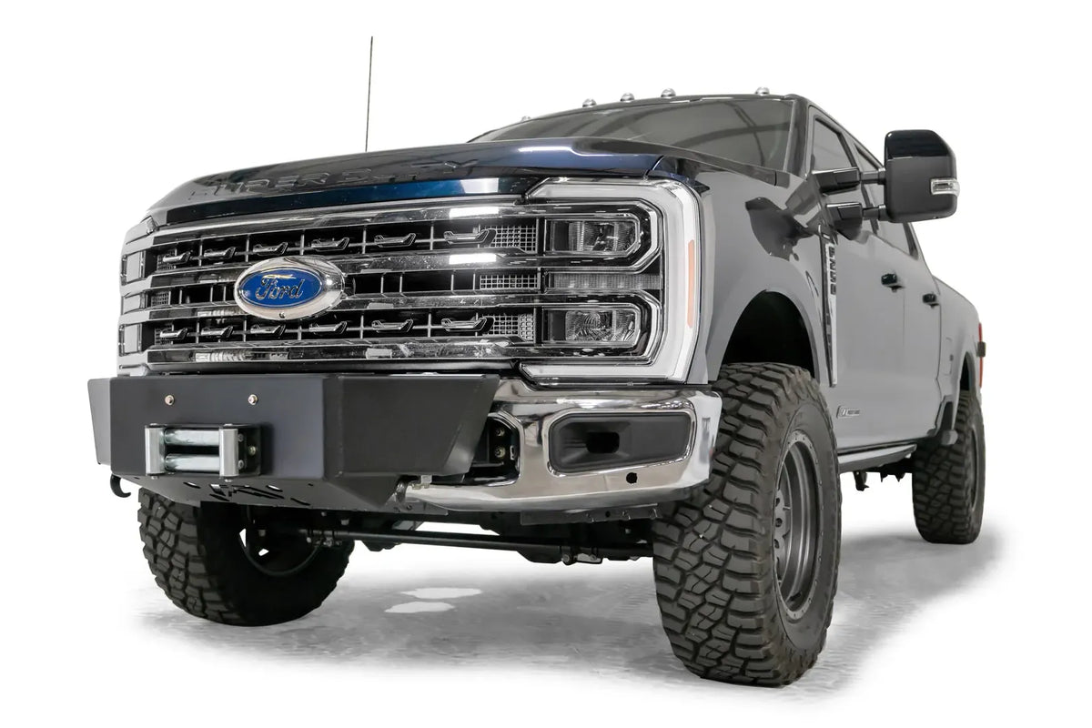 Fab Fours winch mount on a blue and gray two-tone Ford Super Duty F-250/F-350, front driver-side three-quarter view, showing the winch mount plate with fairlead and the factory bumper integration