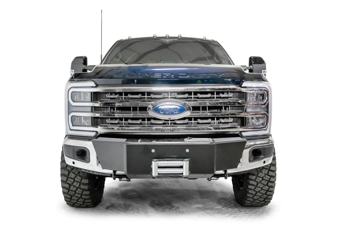 Fab Fours winch mount on a blue and gray two-tone Ford Super Duty F-250/F-350, straight-on front view, showing the winch mount plate with fairlead and the factory bumper integration