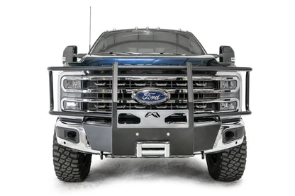 Fab Fours winch mount with full guard on a blue and gray two-tone Ford Super Duty F-250/F-350, straight-on front view, showing full grille guard uprights and hoops, the winch mount plate with fairlead and the factory bumper integration