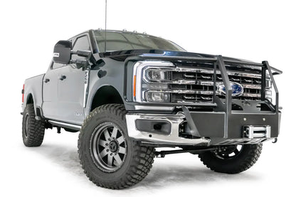 Fab Fours winch mount with full guard on a blue and gray two-tone Ford Super Duty F-250/F-350, front passenger-side three-quarter view, showing full grille guard uprights and hoops, the winch mount plate with fairlead and the factory bumper integration