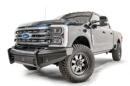 Fab Fours Black Steel Elite front bumper on a blue and gray two-tone Ford Super Duty, front driver-side three-quarter view, showing the smooth steel face, mesh-backed side openings, and the center sensor/plate mount