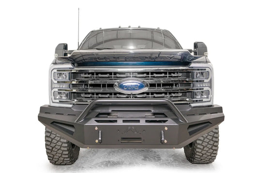 Fab Fours Red Steel front bumper with pre-runner guard on a blue and gray two-tone Ford Super Duty, straight-on front view, showing the tubular pre-runner hoop, the center winch mount plate, and angular steel wings
