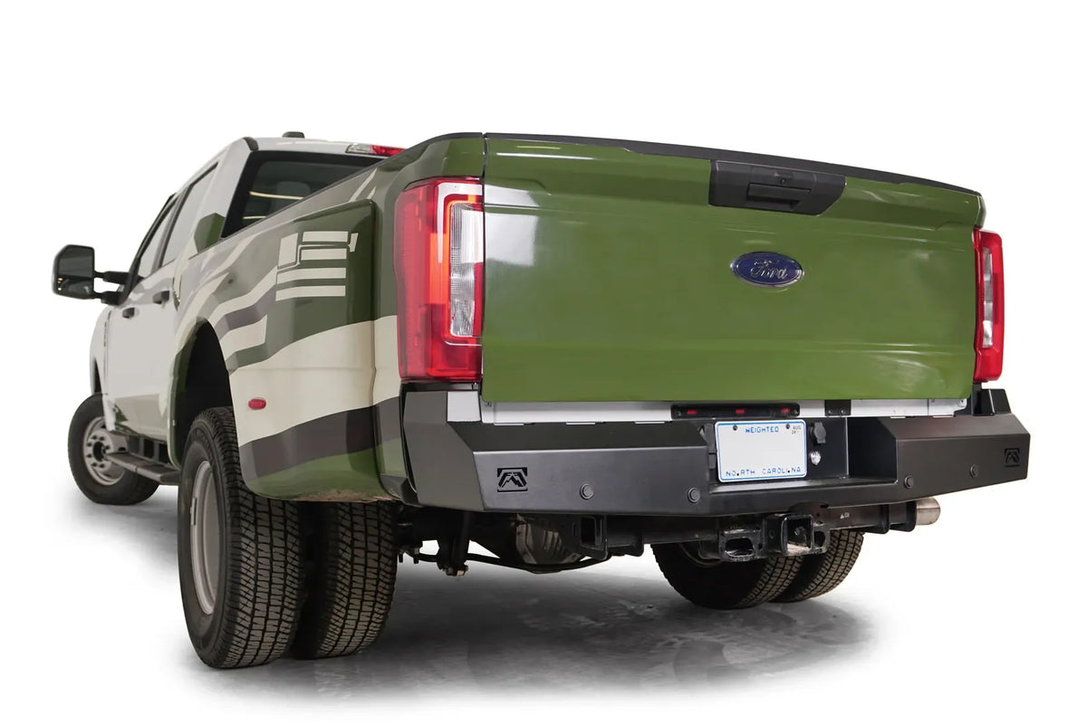 Fab Fours Red Steel rear bumper on a green and white Ford Super Duty dually, rear driver-side view