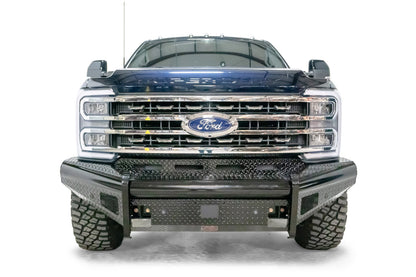 Fab Fours Black Steel front bumper on a blue and gray two-tone Ford Super Duty, straight-on front view, showing diamond-plate face panels, the center sensor/plate mount, and angled side wings
