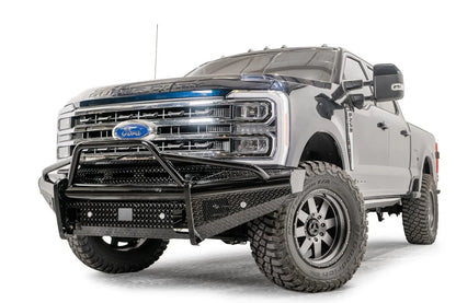 Fab Fours Black Steel front bumper with pre-runner guard on a blue and gray two-tone Ford Super Duty, front driver-side three-quarter view, showing the tubular pre-runner hoop, diamond-plate face panels, the center sensor/plate mount, and angled side wings