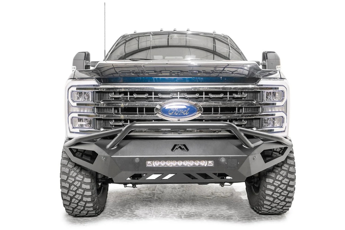 Fab Fours Vengeance front bumper with pre-runner guard on a gray and dark blue two-tone Ford Super Duty, straight-on front view, showing the pre-runner hoop, center LED light bar and sculpted skid plate