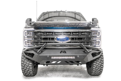 Fab Fours Vengeance front bumper with pre-runner guard on a gray and dark blue two-tone Ford Super Duty, straight-on front view, showing the pre-runner hoop, center LED light bar and sculpted skid plate