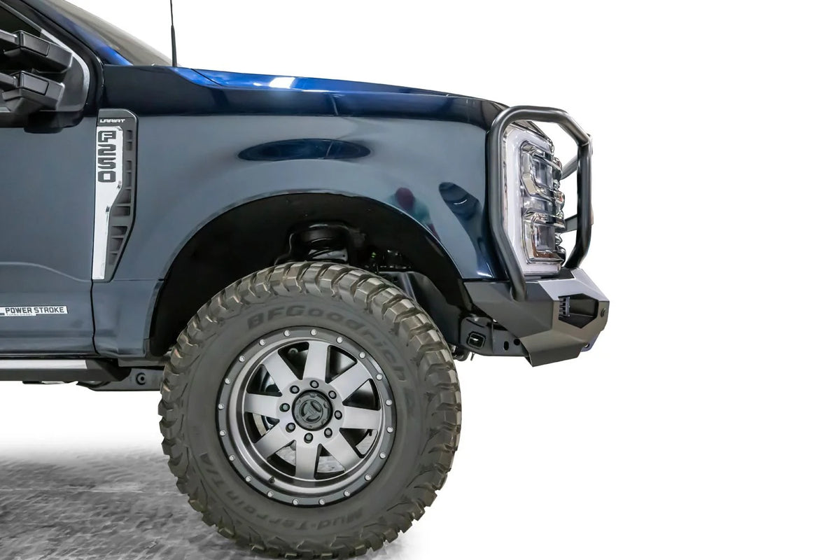 Fab Fours Matrix front bumper with full guard on a dark blue Ford Super Duty F-250, close-up of the driver-side corner, showing the full guard side upright, bumper wing and wheel-well clearance