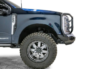 Fab Fours Matrix front bumper with full guard on a dark blue Ford Super Duty F-250, close-up of the driver-side corner, showing the full guard side upright, bumper wing and wheel-well clearance