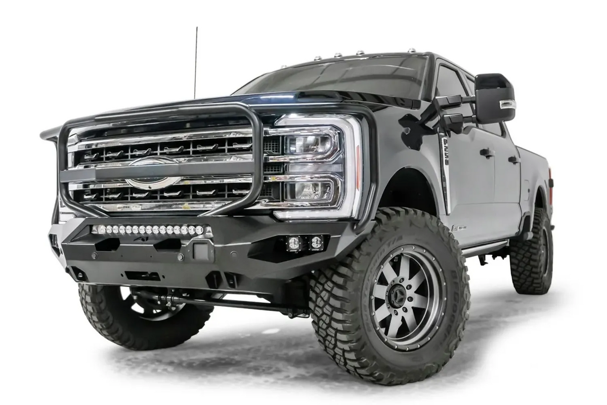 Fab Fours Matrix front bumper with full guard on a gray and dark blue two-tone Ford Super Duty F-250, front driver-side three-quarter view, showing the full grille guard, LED light bar and winch opening