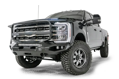Fab Fours Matrix front bumper with full guard on a gray and dark blue two-tone Ford Super Duty F-250, front driver-side three-quarter view, showing the full grille guard, LED light bar and winch opening