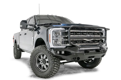 Fab Fours Matrix front bumper with full guard on a gray and dark blue two-tone Ford Super Duty F-250, front passenger-side three-quarter view, showing the full grille guard hoop, LED light bar and cube light pockets
