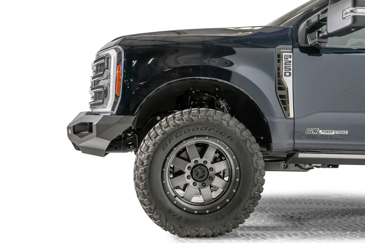 Fab Fours Matrix front bumper on a dark blue Ford Super Duty F-250, close-up of the driver-side corner, showing the no-guard bumper end, wing profile and wheel-well clearance