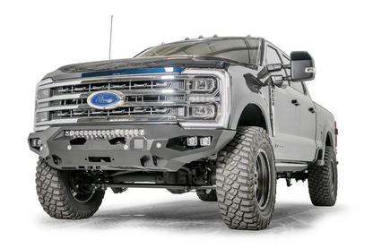 Fab Fours Matrix front bumper on a gray and dark blue two-tone Ford Super Duty F-250, front driver-side three-quarter view, showing the no-guard winch bumper face, LED light bar and cube light pockets