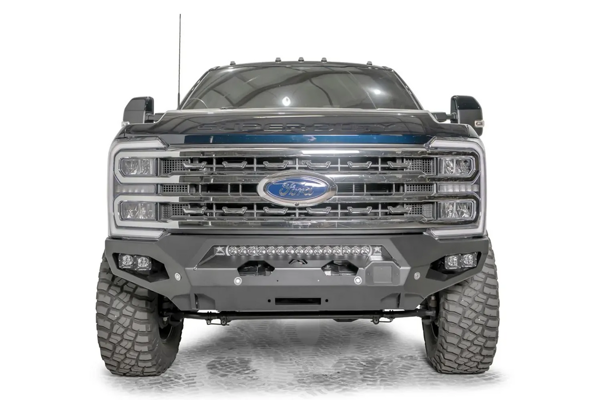 Fab Fours Matrix front bumper on a gray and dark blue two-tone Ford Super Duty F-250, straight-on front view, showing the no-guard winch bumper face, center LED light bar and fairlead opening