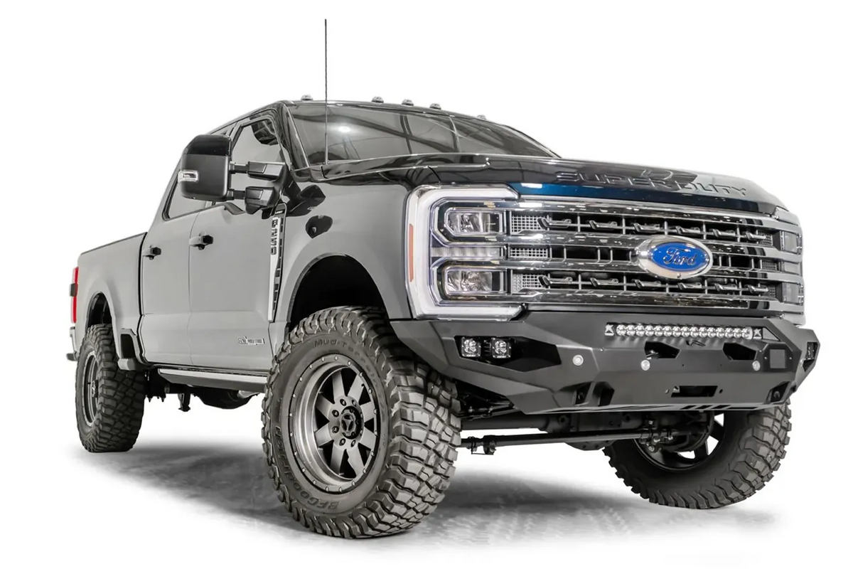 Fab Fours Matrix front bumper on a gray and dark blue two-tone Ford Super Duty F-250, front passenger-side three-quarter view, showing the no-guard winch bumper face, LED light bar and cube light pockets