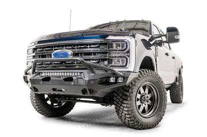 Fab Fours Matrix front bumper with pre-runner guard on a gray and dark blue two-tone Ford Super Duty F-250, front driver-side three-quarter view, showing the pre-runner hoop, LED light bar and winch opening