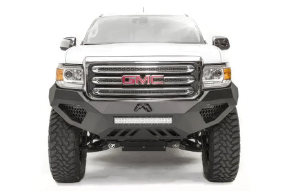 Fab Fours Vengeance front bumper on a white GMC Canyon, straight-on front view, showing the sculpted no-guard face, center LED light bar and honeycomb light pockets