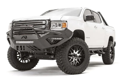 Fab Fours Vengeance front bumper with pre-runner guard on a white GMC Canyon, front passenger-side three-quarter view, showing the pre-runner hoop, integrated LED light bar and honeycomb light pockets