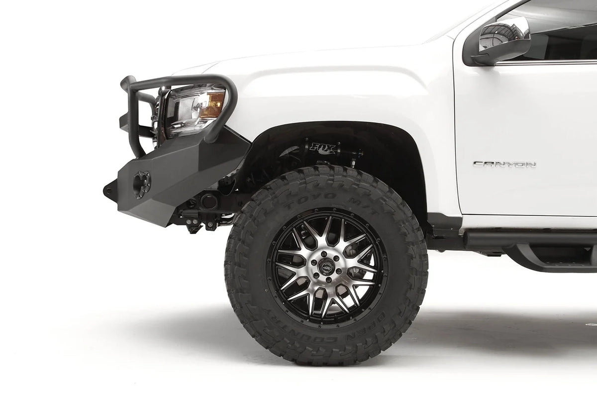 Fab Fours Premium front bumper with full guard on a white GMC Canyon, driver-side corner profile view, showing the full guard side tube, bumper wing and shackle mount
