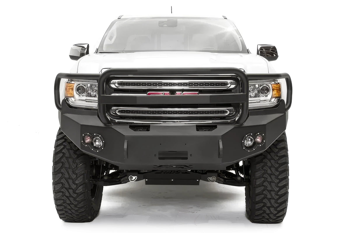 Fab Fours Premium front bumper with full guard on a white GMC Canyon, straight-on front view, showing the full grille guard hoop, center winch opening and round fog light cutouts