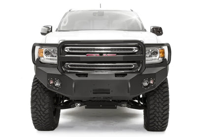 Fab Fours Premium front bumper with full guard on a white GMC Canyon, straight-on front view, showing the full grille guard hoop, center winch opening and round fog light cutouts