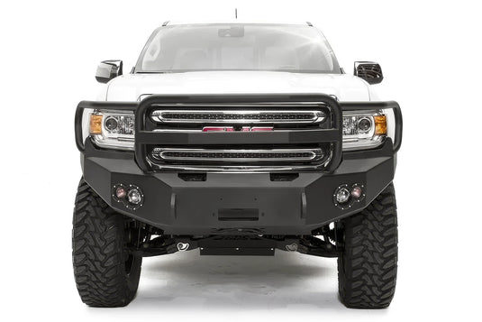 Fab Fours Premium front bumper with full guard on a white GMC Canyon, straight-on front view, showing the full grille guard hoop, center winch opening and round fog light cutouts
