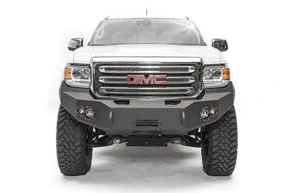 Fab Fours Premium front bumper on a white GMC Canyon, straight-on front view, showing the no-guard winch bumper face, center winch opening and round fog light cutouts