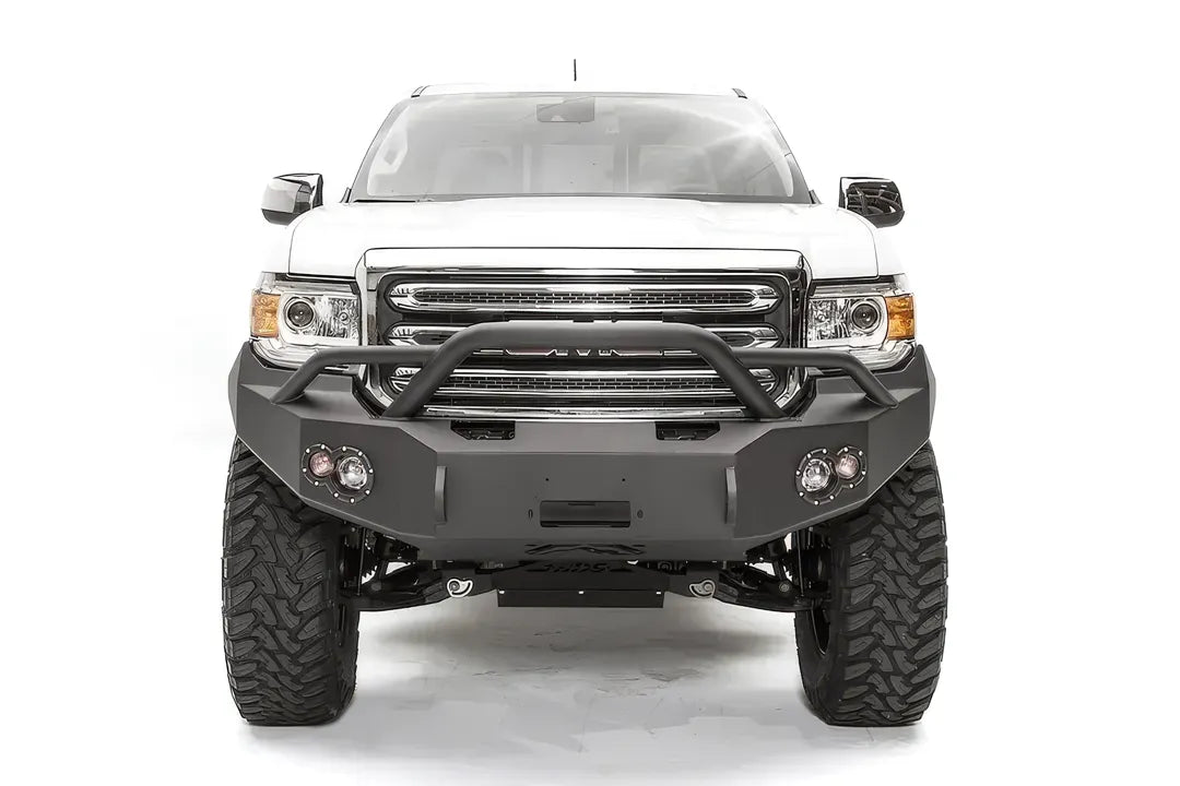 Fab Fours Premium front bumper with pre-runner guard on a white GMC Canyon, straight-on front view, showing the pre-runner hoop, center winch opening and round fog light cutouts