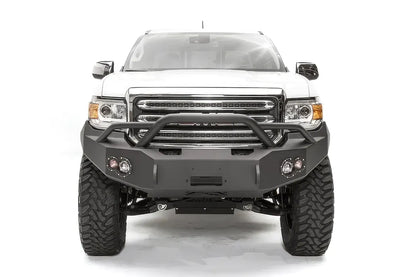 Fab Fours Premium front bumper with pre-runner guard on a white GMC Canyon, straight-on front view, showing the pre-runner hoop, center winch opening and round fog light cutouts