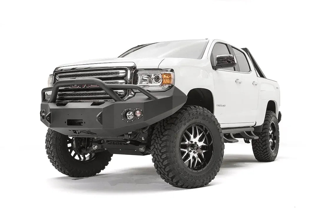 Fab Fours Premium front bumper with pre-runner guard on a white GMC Canyon, front passenger-side three-quarter view, showing the pre-runner hoop, winch opening and round fog light cutouts