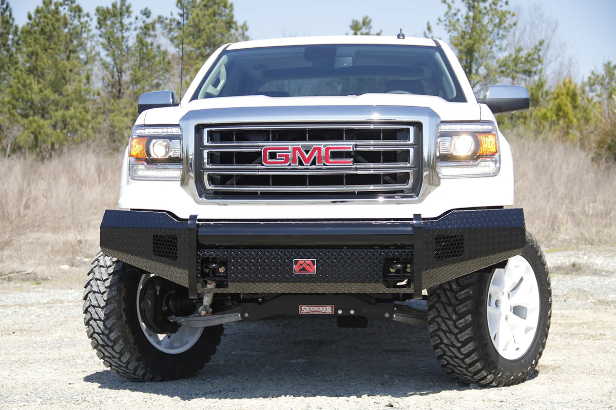 Fab Fours Black Steel front bumper on a white GMC Sierra 1500 parked on gravel, straight-on front view, showing the no-guard diamond-plate face, top tube and center logo plate