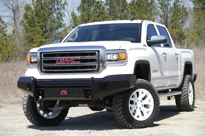 Fab Fours Black Steel front bumper on a white GMC Sierra 1500 parked on gravel, front driver-side three-quarter view, showing the no-guard diamond-plate face, top tube and wrapped wings