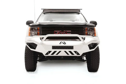 Fab Fours Vengeance front bumper with pre-runner guard on a white GMC Sierra 2500HD, straight-on front view, showing the pre-runner hoop, center light bar opening and slotted skid plate