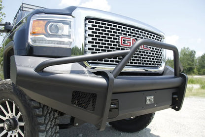 Fab Fours Black Steel Elite front bumper with pre-runner guard on a black GMC Sierra 2500HD, outdoor close-up of the passenger-side corner, showing the pre-runner tube, smooth-plate wing and mesh light opening