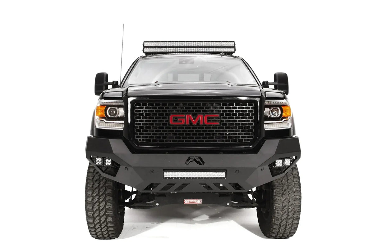 Fab Fours Vengeance front bumper on a black GMC Sierra 2500HD, straight-on front view, showing the sculpted no-guard face, center LED light bar and outboard cube lights