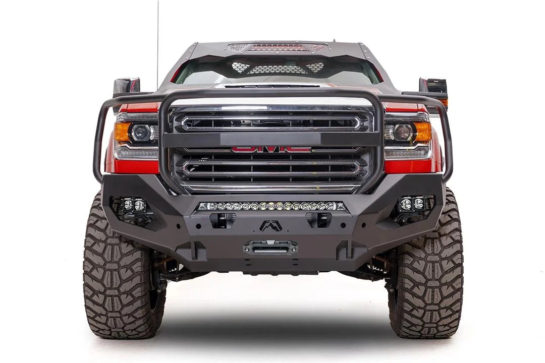 Fab Fours Matrix front bumper with full guard on a red GMC Sierra 2500HD, straight-on front view, showing the full grille guard hoop, center LED light bar and winch fairlead opening