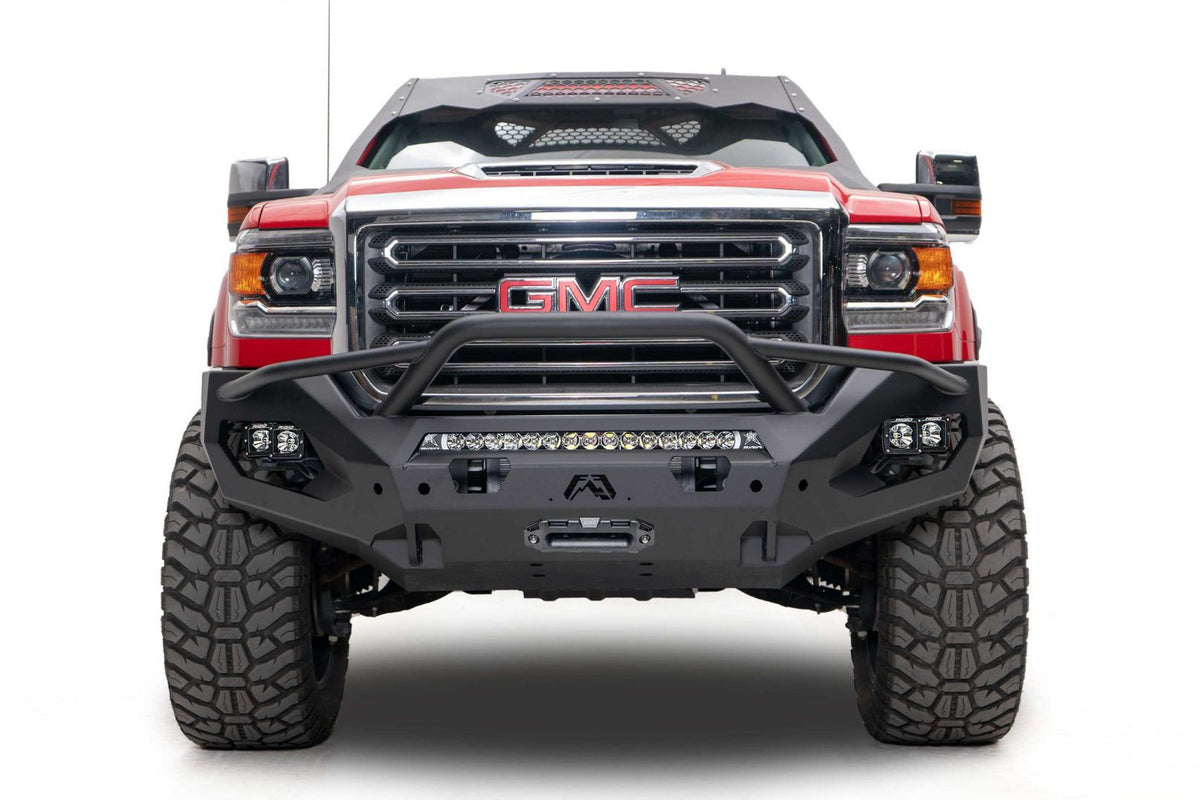 Fab Fours Matrix front bumper with pre-runner guard on a red GMC Sierra 2500HD/3500HD, straight-on front view, showing pre-runner hoop, integrated light bar, cube light pods, winch-ready center