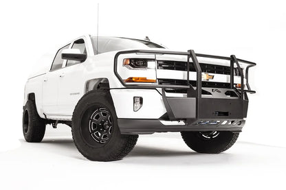 Fab Fours winch mount with full guard on a white Chevrolet Silverado 1500, front passenger-side three-quarter view, showing full grille guard uprights, winch plate, wraparound headlight hoops