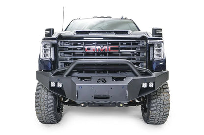 Fab Fours Premium Winch front bumper with pre-runner guard on a blue and gray GMC Sierra 2500HD/3500HD, straight-on front view, showing pre-runner hoop, winch mount opening, cube light pods