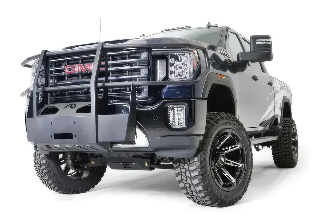 Fab Fours winch mount with full guard on a blue and gray GMC Sierra 2500HD/3500HD, front driver-side three-quarter view, showing full guard uprights, wraparound headlight hoops, winch plate