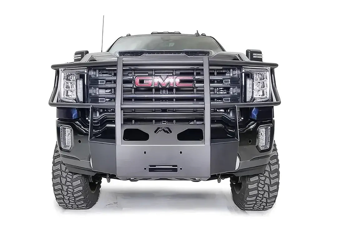 Fab Fours winch mount with full guard on a blue and gray GMC Sierra 2500HD/3500HD, straight-on front view, showing full guard uprights, wraparound headlight hoops, winch plate