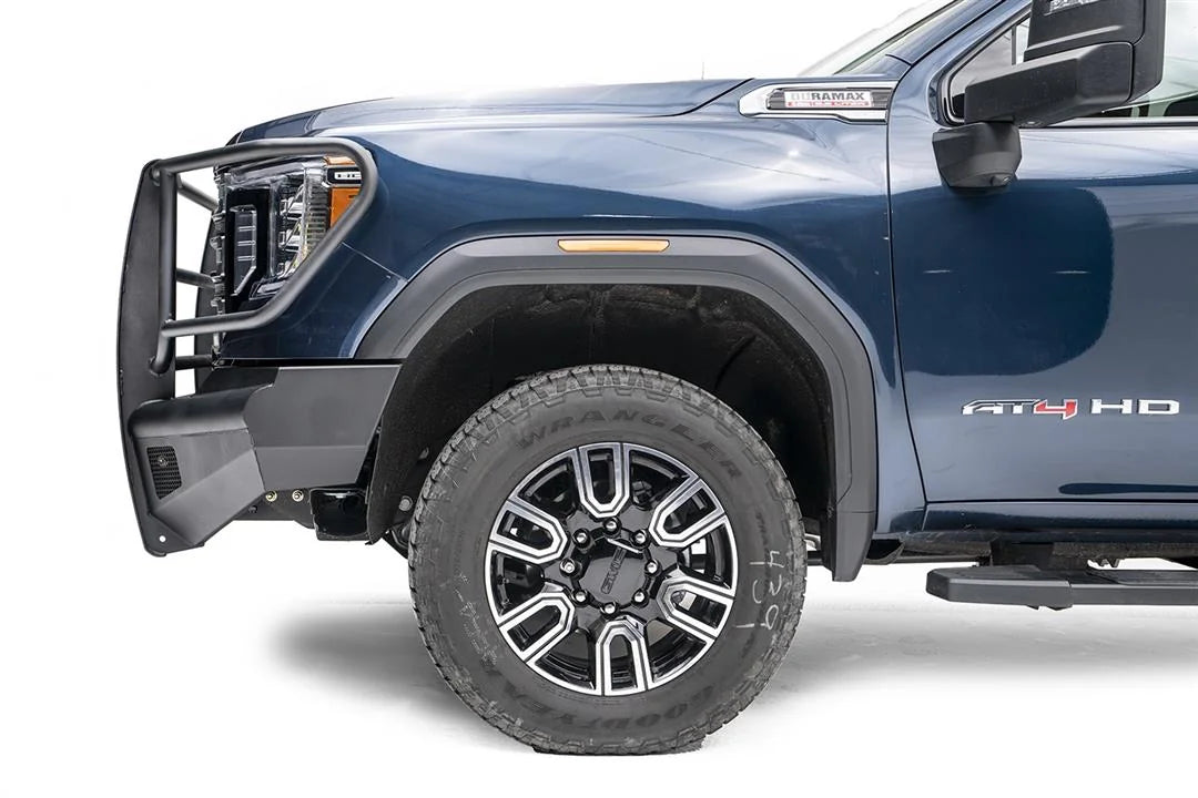 Fab Fours Black Steel Elite front bumper with full guard on a blue GMC Sierra 2500HD/3500HD, close-up of the front corner, showing full guard side hoop, bumper end profile, wheel-well clearance
