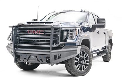 Fab Fours Black Steel Elite front bumper with full guard on a blue GMC Sierra 2500HD/3500HD, front driver-side three-quarter view, showing full grille guard, Elite badge, slotted skid plate, mesh end inserts