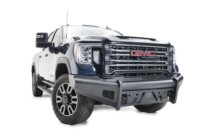 Fab Fours Black Steel Elite front bumper on a blue GMC Sierra 2500HD/3500HD, front passenger-side three-quarter view, showing Elite badge, slotted skid plate, mesh end inserts, top tube