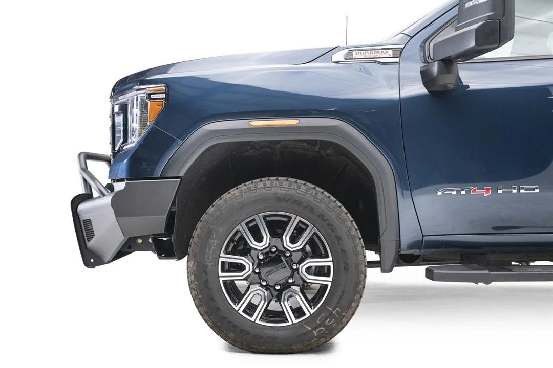 Fab Fours Black Steel Elite front bumper with pre-runner guard on a blue GMC Sierra 2500HD/3500HD, close-up of the front corner, showing pre-runner hoop, bumper end profile, wheel-well clearance